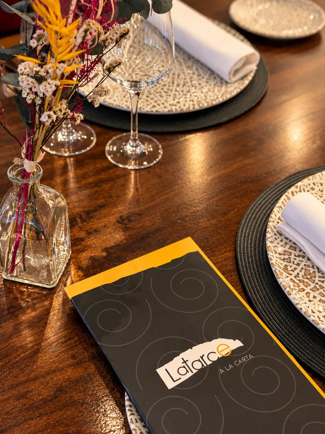 Mesa puesta en el restaurante Latarce, con la carta sobre la mesa
