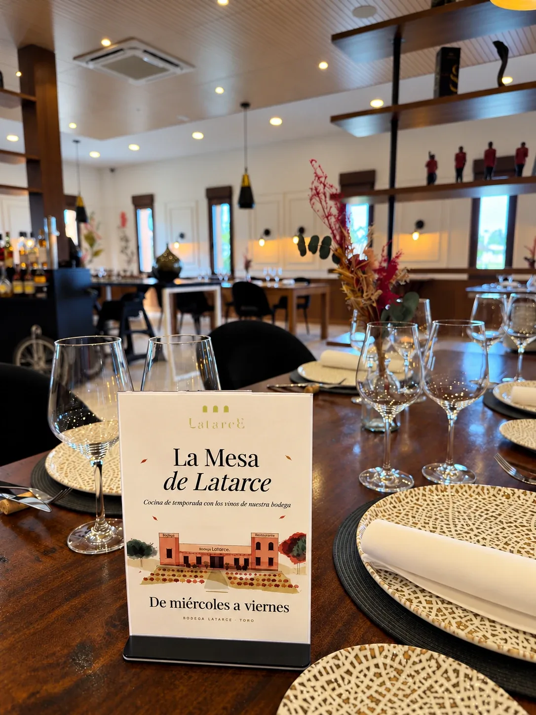 Mesa puesta en el restaurante Latarce con el cartel del menú La mesa de Latarce