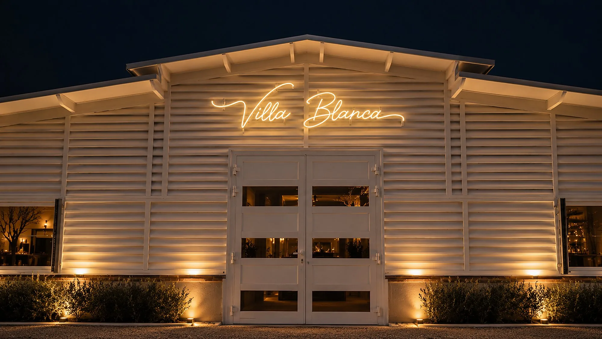 Villa Blanca iluminada de noche, entrada a los jardines de Bodega Latarce